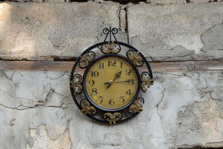 old broken clock ussr hangs on the white wall of a house in the street in the sun, broken old wall clockの写真素材