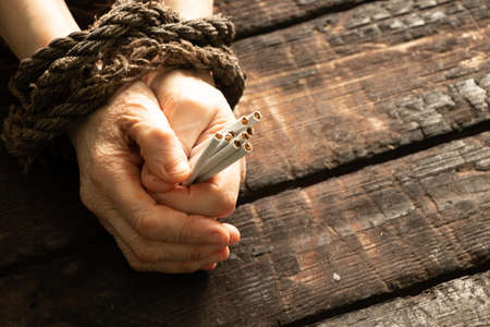 old woman holds cigarettes tied with rope, addiction to smoking, stop smoking