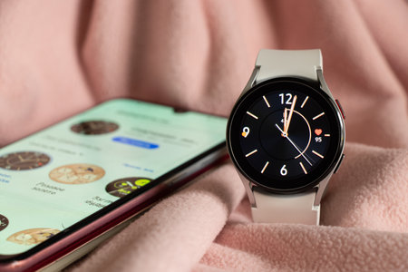 Ukraine Dnepr 11.12.2021 - Smart watch Samsung Galaxy Watch 4 track with a gray strap on an isolated background and an application, a new watch a giftのeditorial素材