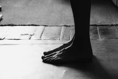 female feet on the old floor barefoot in the dark, body parts, legsの写真素材