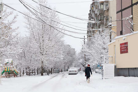 Ukraine Dnipro 26.12.2021 - City in winter with cars in the snow and people trying to get to the robot in the morning after snowfall, winter in the cityのeditorial素材