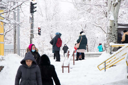 Ukraine Dnipro 27.12.2021 - City dwellers in winter on the street in a sleeping area In the morning they go to the robot, winter in the cityのeditorial素材