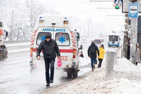 Ukraine Dnipro 27.12.2021 - Ambulance on the road in winter in the snow, old rusty ambulance in the center of the city in the snow in winter on the roadのeditorial素材
