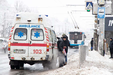 Ukraine Dnipro 27.12.2021 - Ambulance on the road in winter in the snow, old rusty ambulance in the center of the city in the snow in winter on the roadのeditorial素材