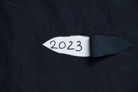 2023 written on paper on torn fabric, happy new year 2023