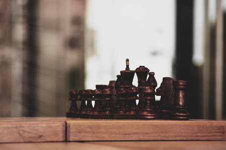brown chess board with figures on a wooden table in a cafe, playing chess