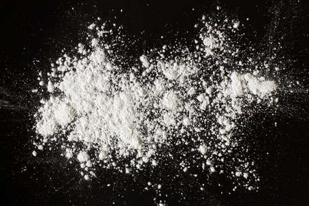 white powder on black background, flour sprinkled for background