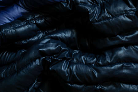 black puffed men's winter jacket as background, down jacket close-upの写真素材