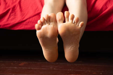 bare feet on the bed, the girl sleeps on the bed at home