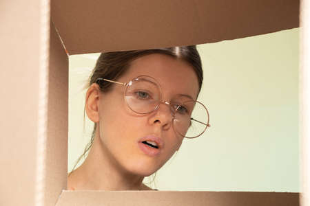 the girl's face looks into the cardboard box, receiving the parcel, look through the box
