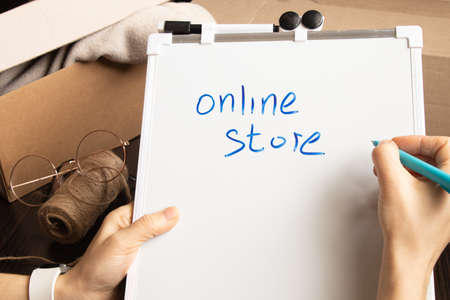 Women's online store, small business owner, entrepreneur, mailbox prepares a parcel on the table for shipment. Dropshipping delivery concept in e-commerce, on tablets on written online storeの写真素材