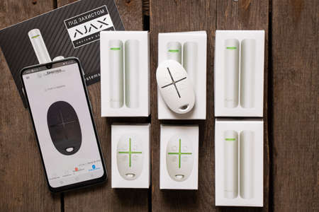 Ukraine Dnipro 08.02.2022 - A new Ajax wireless alarm and remote control button lie on a wooden...