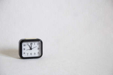 old black alarm clock on a white background close-upの写真素材