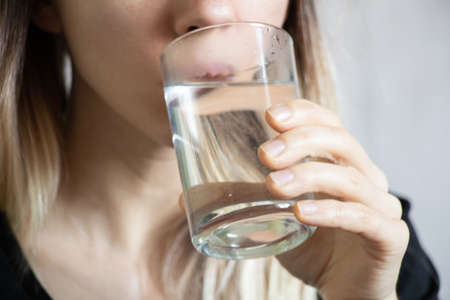 girl drinks water from a glass, water in a glass