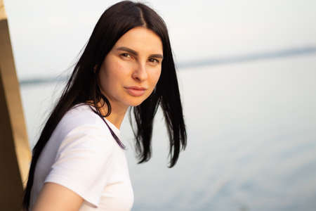 portrait of a brunette girl in the parks in the summer in the sun, the girl is beautiful