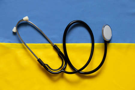 The stethoscope lies on the national flag of Ukraine yellow-blue, martial law in Ukraine, medical care in the warの写真素材