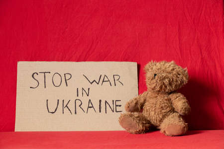 Stop the war in Ukraine is written on a sign that stands at home in Ukraine near a teddy bear. Peace in Ukraine. protest actionの写真素材