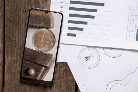 The gas key holds the Russian ruble as a background in the phone, the collapse of the ruble, sanctions against Russia, the economic crisis in Russia and losses, online news 2022の写真素材