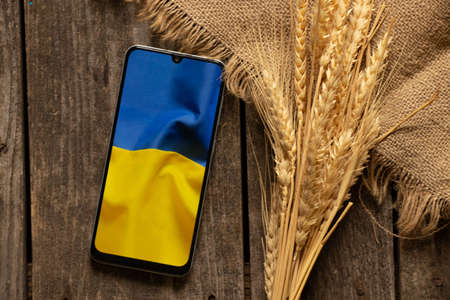 The national flag of Ukraine as a background on the phone, peace in Ukraine, no war, free country, war in Ukraine 2022の写真素材