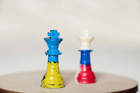 Flags of Ukraine and Russia paint over the chess king of Ukraine against Russia.Chess battles...