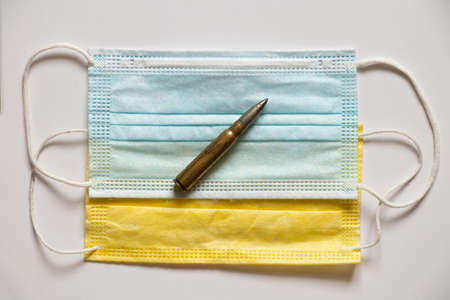 Yellow and blue medical masks, such as the flag of Ukraine and a military bullet. Medicine during...