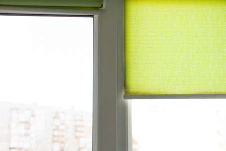 metal-plastic window and green blinds in an apartment in Ukraine of a residential building, sunlight...