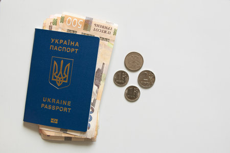 Foreign Ukrainian passport and hryvnia lie next to Russian rubles on a white background, economy and...