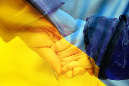Mother holds a little girl by the hand against the background of the national flag of Ukraine yellow-blue. Peace in Ukraine, stop the war 2022の写真素材