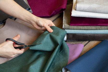 Female hands cut different pieces of fabric on the table, tailor workshop, sewing and fashion, tailoringの写真素材