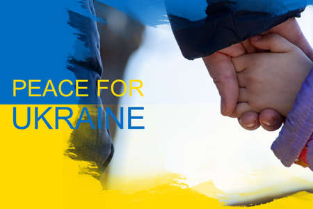 A mother holds a little girl by the hand against the background of the yellow-blue state flag of Ukraine. Peace in Ukraine, stop the war 2022の写真素材