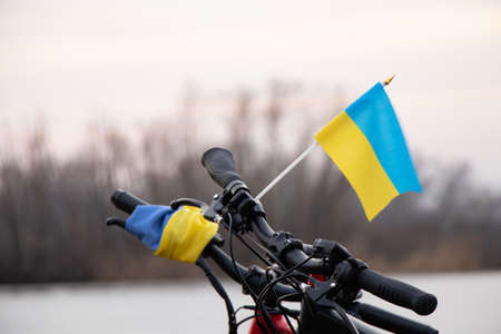 Yellow-blue flag of Ukraine on a bicycle in a city in Ukraine, a protest action, stop the war in Ukraine, a patriot of his country 2022の写真素材