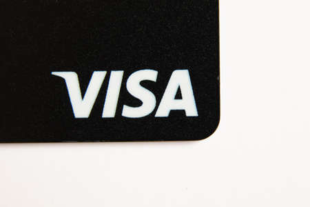 Ukraine Dnepr 01.04.2022 - One black Visa bank card on a white background, sanctions, disconnection from the Swift Russia Systemのeditorial素材