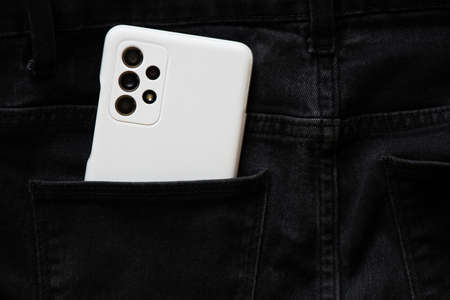 Ukraine Dnipro 05.04.2022 - A new Samsung A52 smartphone in a white case lies in the pocket of gray pants, buys new gadgetsのeditorial素材