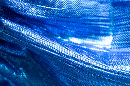 Shiny blue fabric as background macro photo, festive packaging shiny backdrop