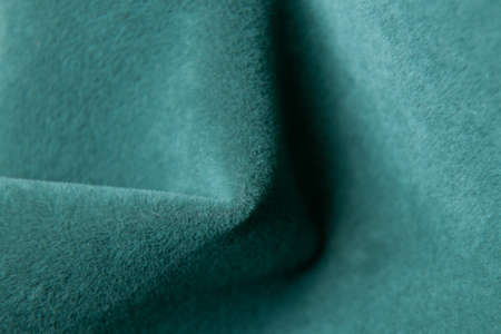 Green fabric as a background, velor soft fabric, green wrinkled fabric with a wave