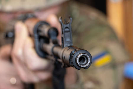 A Ukrainian soldier in military uniform holds a machine gun, the war in Ukraine and the protection...