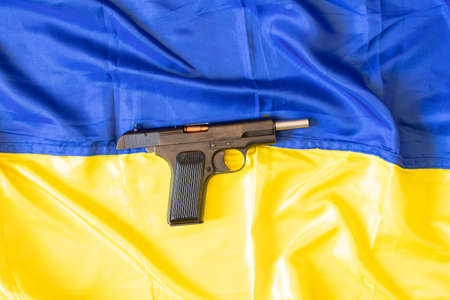The gun lies on the yellow-blue flag of Ukraine, the war in Ukraine 2022