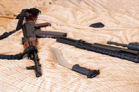 A firearm and a knife lie on a cloth, a military weapon, a soldier's gun in a war 2022