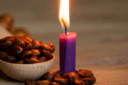 Coffee roasted coffee beans and candle flame on the table in the dark ,coffee backgroundの写真素材