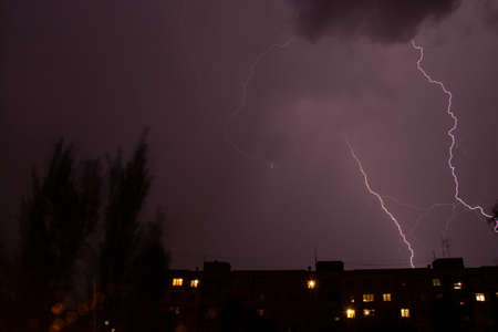 Lightning at night with heavy rain and thunder over Ukraine, lightning over the city in the night sky over the houseの写真素材