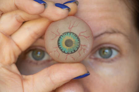 The girl holds a ball in the form of an eye on her forehead between the eyes, the third eye,...