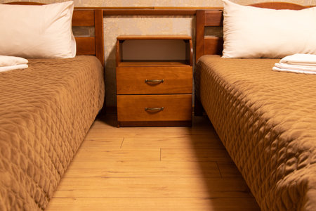 Two single beds and a bedside table with drawers in the bedroom, bedroom, apartment and interior, bedside tableの写真素材