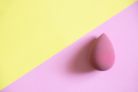 Pink sponge on a pink and yellow background, beauty and makeup, cosmeticsの写真素材
