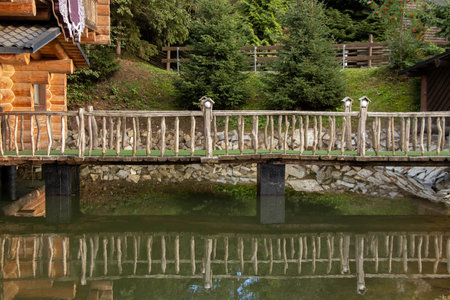 Wooden house on the lake across the bridge in the mountains in the Carpathians in Ukraine, a house on the lakeの写真素材