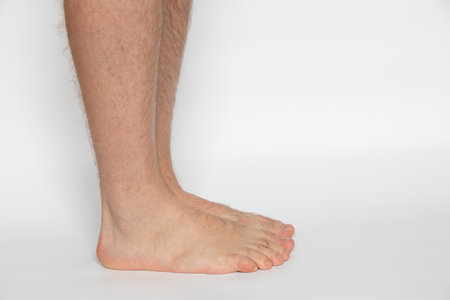 Men's legs on a white background close-up, health and body