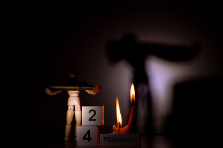 Wooden calendar with the date February 24, the first day of the war in Ukraine and a wooden man...
