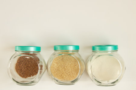 A jar of rice, buckwheat and sugar on a white background close-upの写真素材
