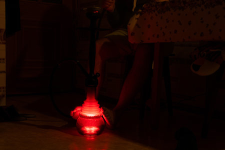 A man smokes hookah in the kitchen in the dark during a power outage in Ukraine, we cannot be...