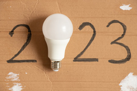 Led light bulb and written year 2023 on brown paper ,new technology in the new year,light
