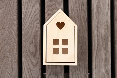 A small wooden house stands on a striped wooden background, a dream homeの写真素材